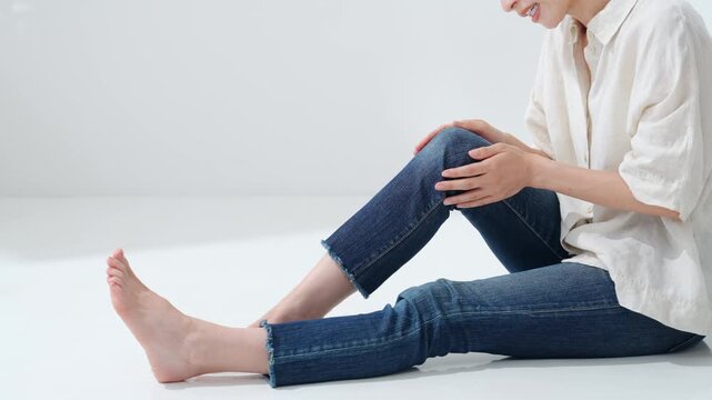A woman stroking her feet. Pain, muscle pain, fatigue, calf pain, joint pain, massage, foot care, relaxation.