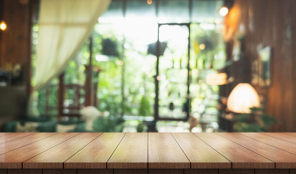 Empty wooden table top with lights bokeh on blur restaurant background.
