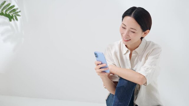 スマホを見るミドル女性。スマートフォン、アプリ、SNS、動画、ゲーム、ネット、ポイント、クーポン