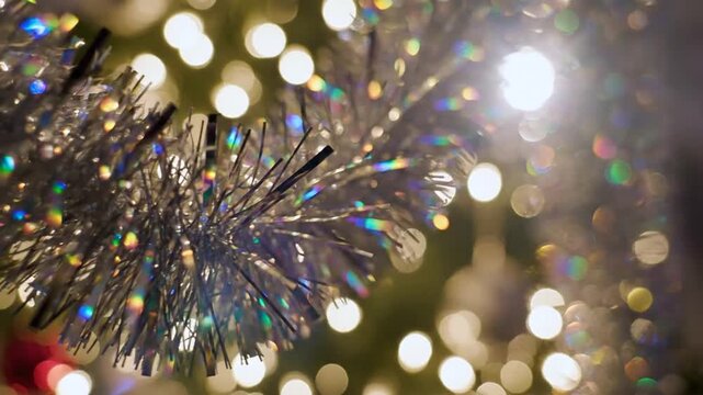 Silver metallic tinsel garland with blurred festive bokeh light background