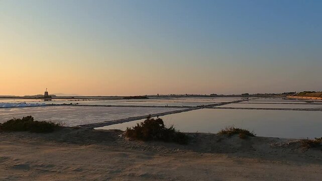 Golden sunset over tranquil salt pans near Trapani, Italy