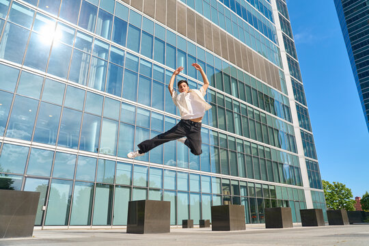Young man jumping in urban city environment