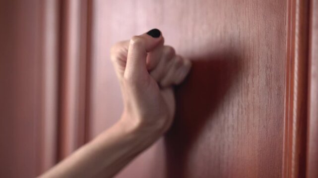 Close up of hand knocking on door. Knocking on door with fist	
