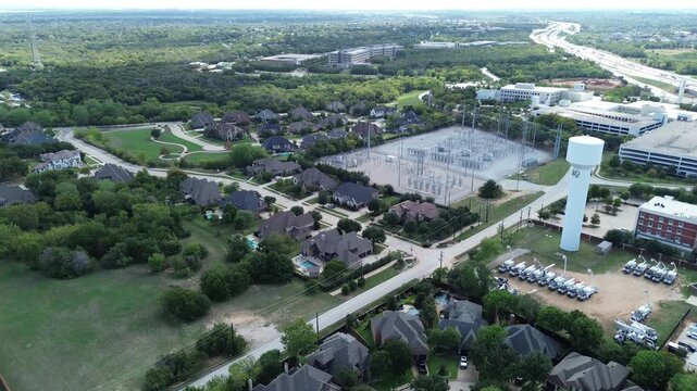 Sprawling suburban developments flank prominent utility facilities across busy Corridor along Westlake. High vantage reveals corporate complexes, residential roofs, regional, Texas