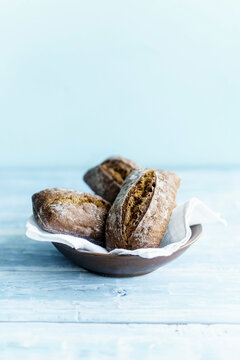 Three Russian rye buns dusted with flour rest on a white napkin
