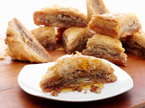 Greek Baklava slices with nut filling and honey on plate