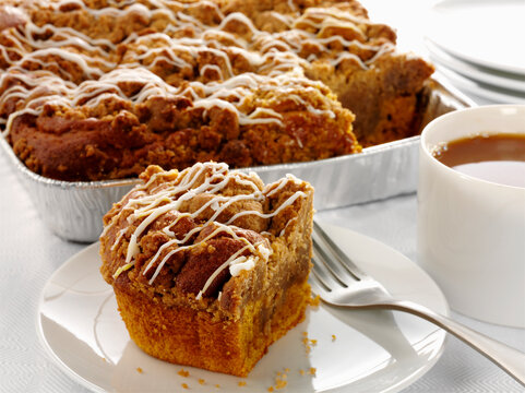 Pumpkin spice coffee cake slice with coffee cup