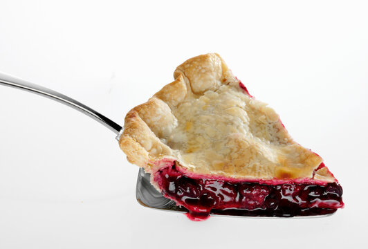 Slice of three berry pie with red berry filling
