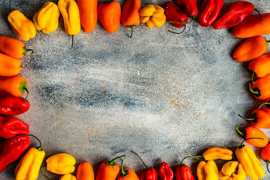 Fresh chili and bell pepper frame with yellow, orange