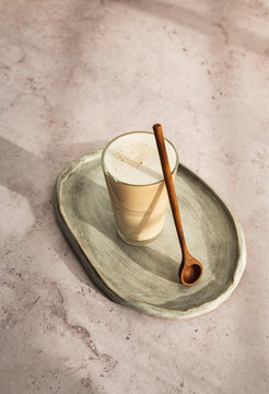 Coffee latte with plant milk and milk foam on gray background