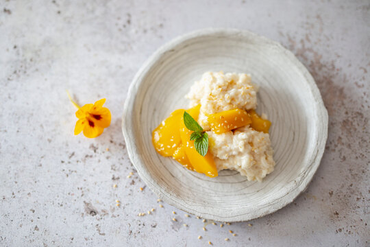 Thai coconut rice dessert with mango and sesame seeds