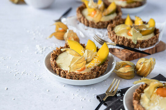 Muesli tartlets topped with mango cream and physalis fruit