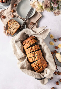 Hazelnut banana bread sliced on table with knife and plates