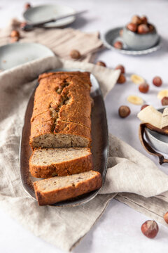 Banana bread with hazelnuts sliced on plate with linen cloth