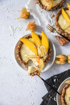 Muesli tartlet with mango cream and cape gooseberry topping