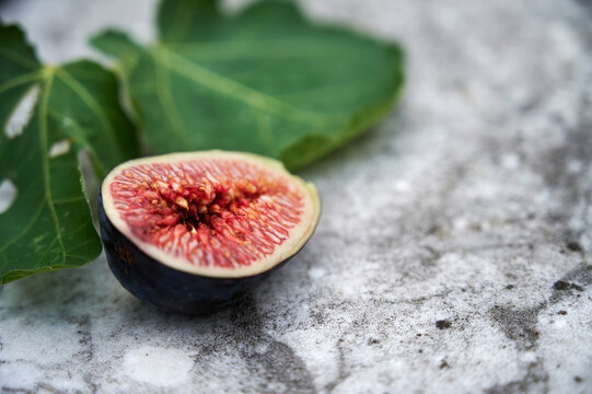 Halved fig with fig leaf in studio still life