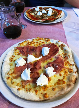 Two different pizzas on a restaurant table