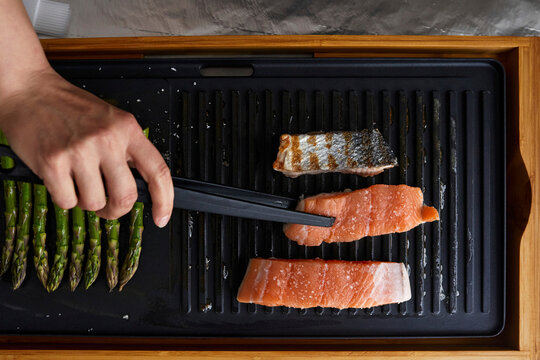 Salmon fillets and asparagus grilled on pan