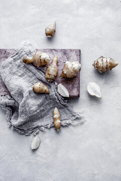 Jerusalem artichokes on stone board with linen cloth
