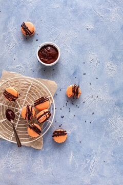 Macarons with chocolate drizzle and sprinkles on cooling rack