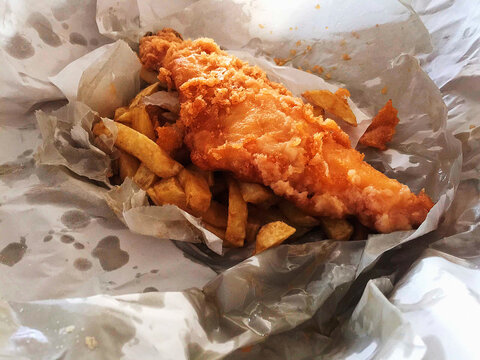 Fish and chips with battered fried Fish and french fries in paper