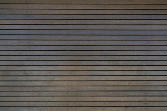 Dark brown varnished wood background with narrow horizontal slats and repeating lines