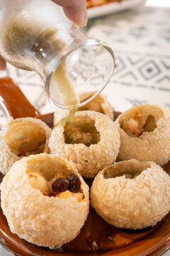 Traditional Indian panipuri golgappa snack served with mint flavored water.