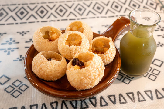 Traditional Indian panipuri golgappa snack served with mint flavored water.