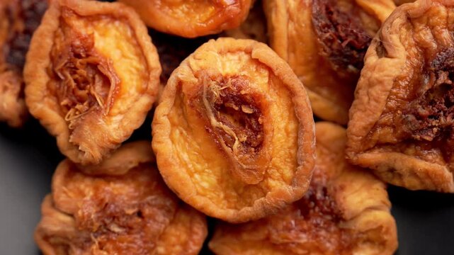 Heap of sun-dried orange peach halves with chewy pulp texture. Healthy organic dehydrated fruits