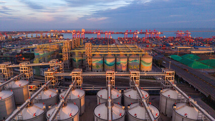 Coastal Grain Reserve Base Under Morning Light, Backed by Seaport and City © Zhaorui