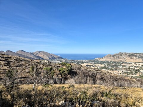  Panoramic mountain viewpoint overlooking valleys, hills, urban settlements and the Mediterranean coastline. Expansive landscape showcasing the natural beauty of Italy.

