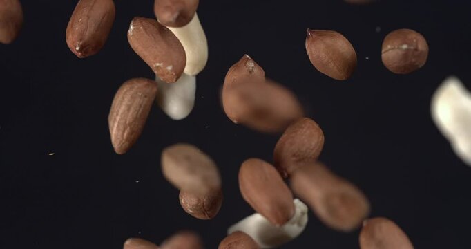 Peanuts falling in slow motion 1000 fps on black background