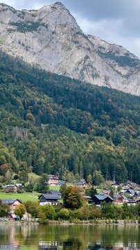 Breathtaking landscape of grundlsee lake in the austrian alps. The serene water reflects the majestic mountains and a peaceful village