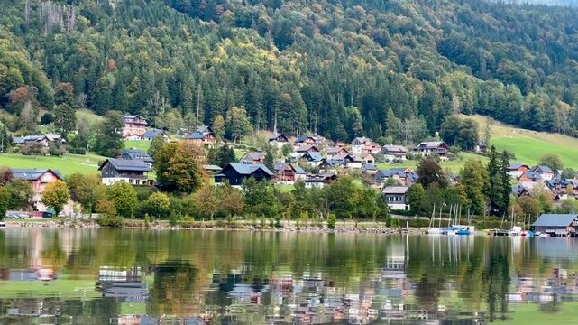 Beautiful alpine landscape of grundlsee lake with a tranquil village reflecting on the clear mountain water in salzkammergut, austria
