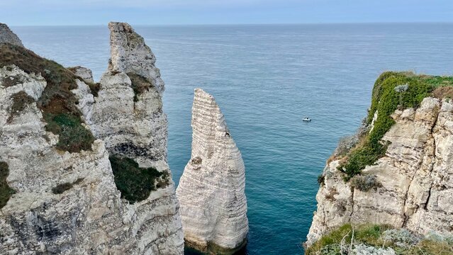 L'Aiguille rock needle framed by chalk cliffs, Etretat, France