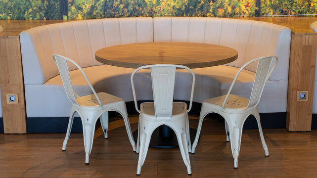 Contemporary Restaurant Dining Space with a Round Wooden Table and Chairs