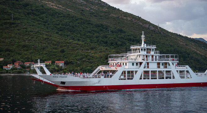 White and red passenger ferry Ruka Pravde cruises across the water in Lepetane, Montenegro on August 5, 2026