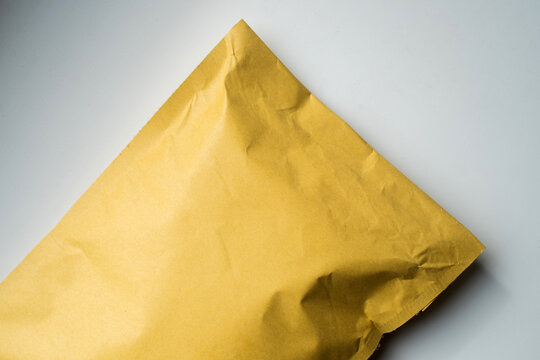 Yellow kraft padded bubble mailer envelope on white background for e-commerce delivery and shipping mockup concept