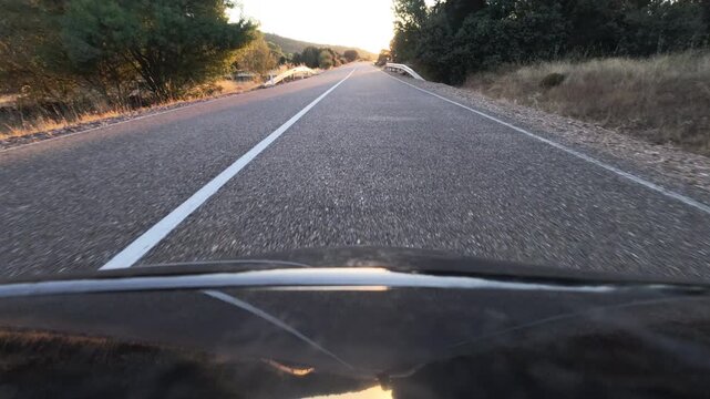 Driving Toward Blinding Sunset on a Mountain Rural Road