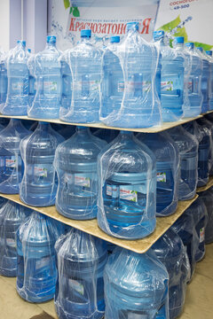 Stacks of Krasnozatonskaya 19 liter drinking water bottles at distribution point in Ukhta, Russia