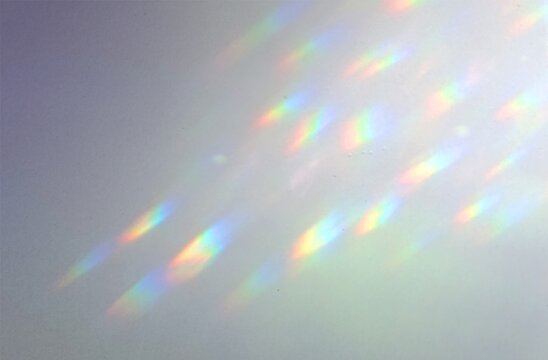 Rainbow suncatcher light reflections, soft leak effect with prism spots on pale grey wall, dreamy spectrum glow texture for photo overlay, refracted sunlight background