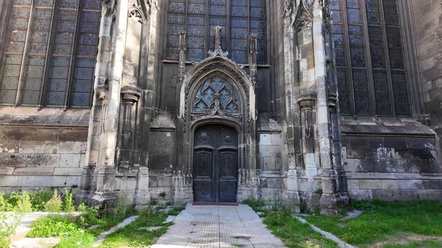 Gothic entrance of Abbatiale Saint-Ouen in Rouen, France with an ornate pointed arch, carved stone details and tall stained glass windows
