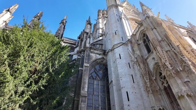 Exterior reveal of Abbatiale Saint-Ouen in Rouen, France showing Gothic stonework, ornate tracery, pointed arches and stained glass windows