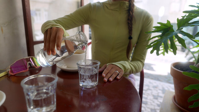 Woman Pours Water From Bottle Into Glass
