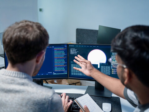 Professional programmers support the training of helping employee write code on computers for software AI development. Team engineer brainstorming is looking at coding cybersecurity analyzing website 