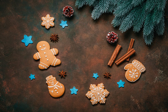 Round frame of various gingerbread cookies with Christmas decorations on dark grunge background, top view, flat lay, copy space