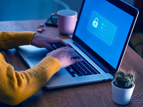Woman typing login credentials on laptop screen