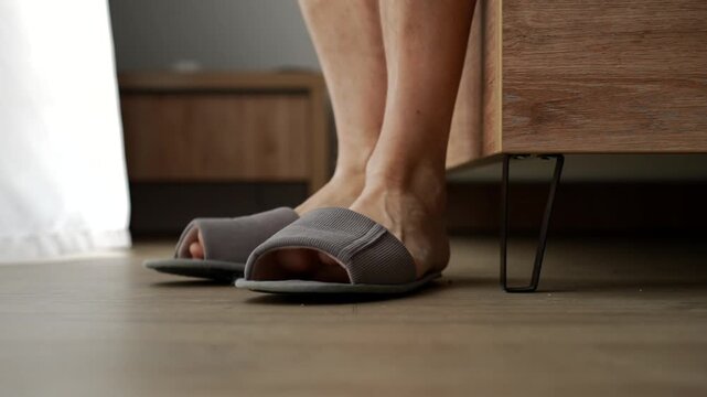 Close-up of slippers on feet. A person gets out of bed and puts on their slippers.