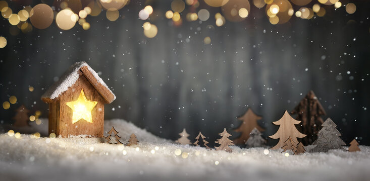 Christmas scene with little lantern on snow, hanging lights and gray blurred background with copy space