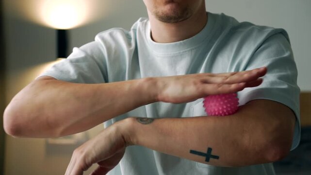 Man Performing Self-Massage with Therapy Ball to Relieve Arm and Shoulder Tension